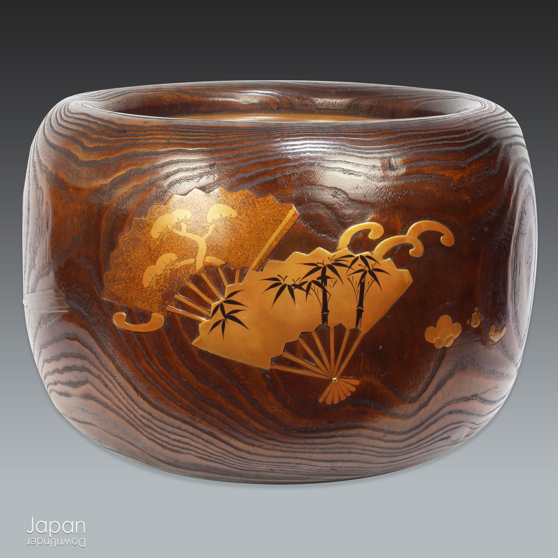 Infuse your home with the charm of Japanese tradition with this stunning antique hibachi heating pot. Adorned with intricate gold makie lacquer fans, this lovely piece seamlessly blends artistry and functionality, making it perfect as a decorative object, vase, or planter. A rare and beautiful find for those who appreciate vintage decor with a touch of elegance and history.