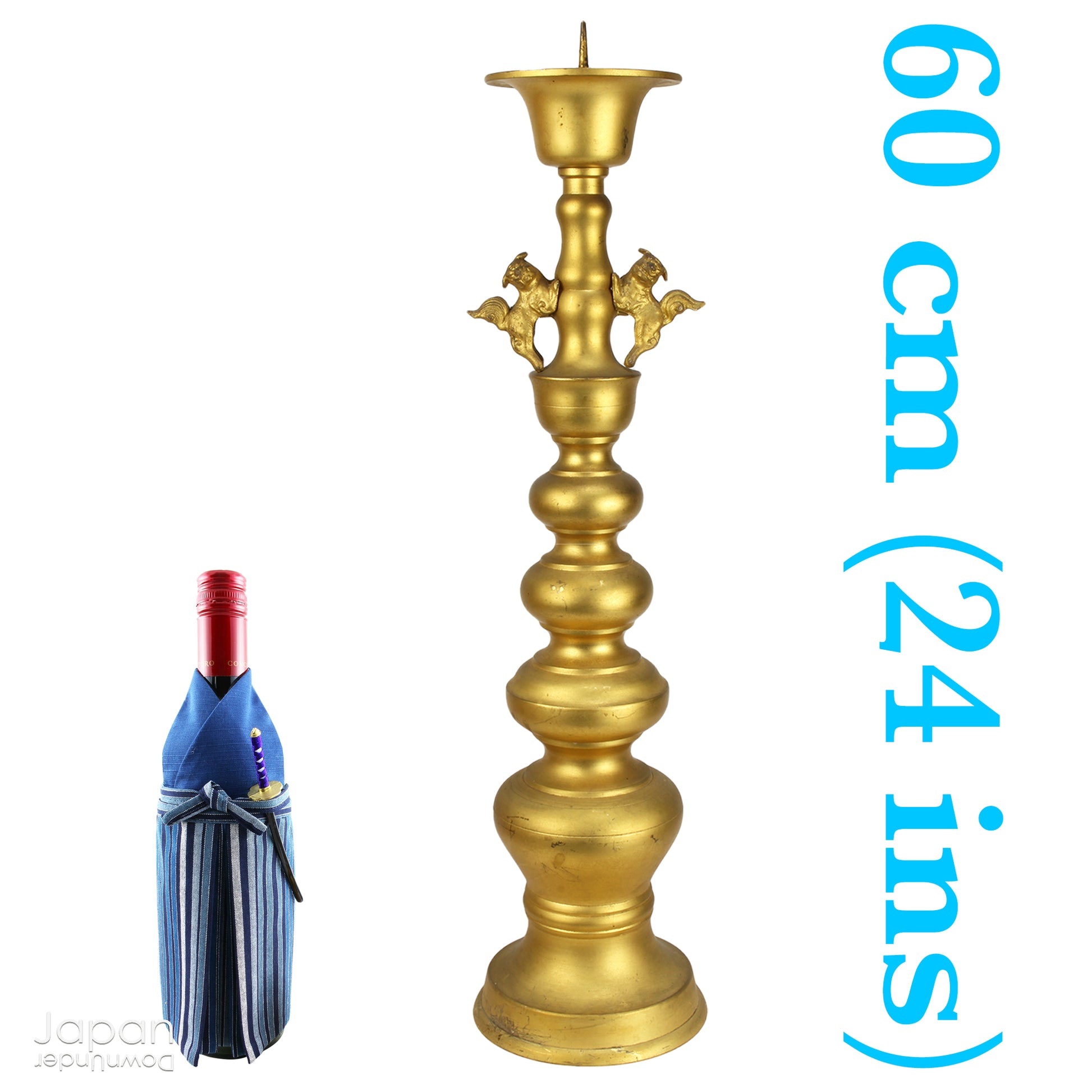 An antique Buddhist temple candle holder.    The gilded brass candle holder is a cylindrical shape, formed of spheres,  gradually decreasing in size as they move upwards. Just below the candle cup hang a pair of Japanese komainu, or lion dogs.