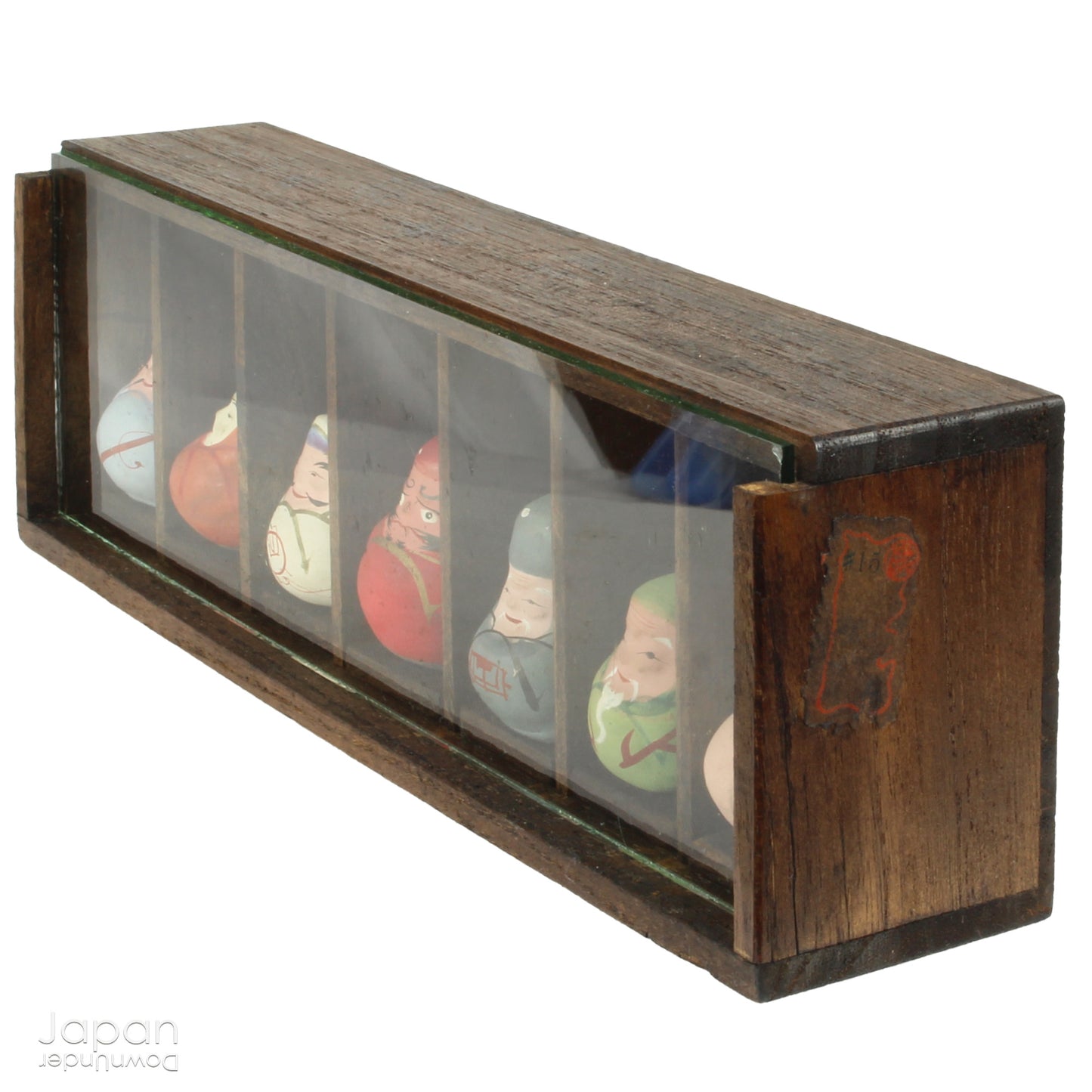 Invite good fortune and timeless tradition into your home with this quaint set of miniature antique Daruma charms. Housed in a charming wooden and glass display box, this unique collection adds an elegant and meaningful touch to your decor, perfect for any space seeking a blend of tradition, luck, and positive energy.
Crafted in the 1920s, this set features hand-painted clay Daruma figures representing the Seven Lucky Gods of Japan, each with its own powerful symbolism.