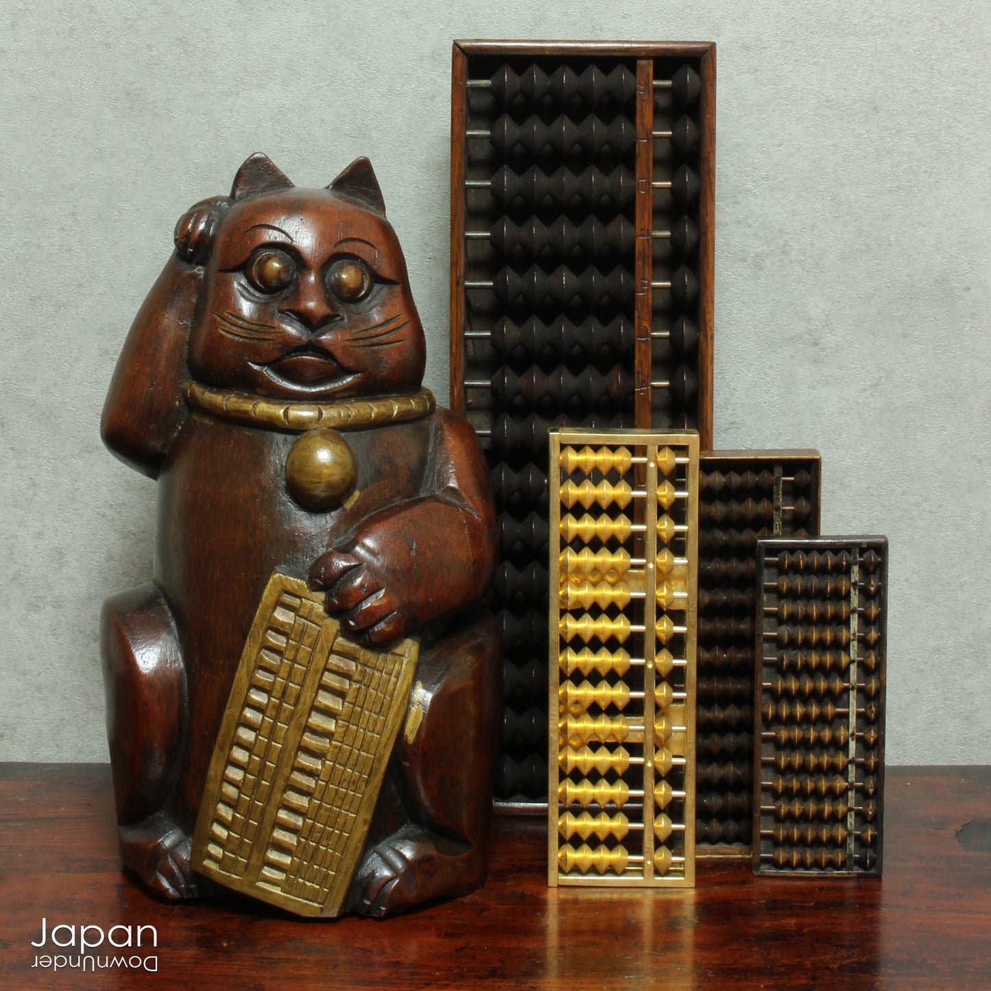 Add a touch of vintage charm to your home or office with this quaint Japanese maneki neko lucky cat. Crafted from bamboo, this larger sized cat,holding an abacus, is believed to beckon in wealth and good luck. Perfect for infusing positive energy and a touch of nostalgia into any space.