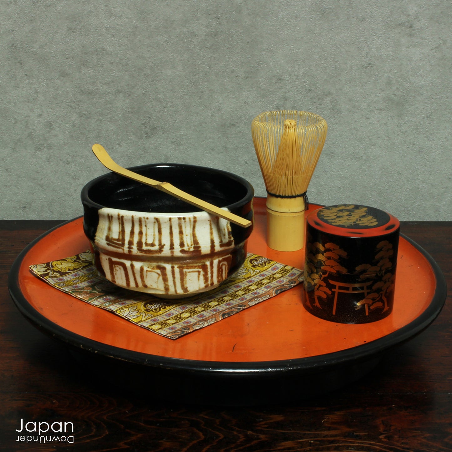 Experience the perfect blend of tradition and modernity with this stunning black Oribe matcha tea bowl. Crafted by the talented artist Yoshiyuki Sone, this unique piece boasts a contemporary design with a striking brown and beige geometric accent that adds a touch of sophistication to any tea ceremony.
The glossy black glaze of the bowl, paired with a minimalistic rectangular design, creates a striking contrast against the vibrant green matcha, making each sip feel even more special. True to the Oribe styl