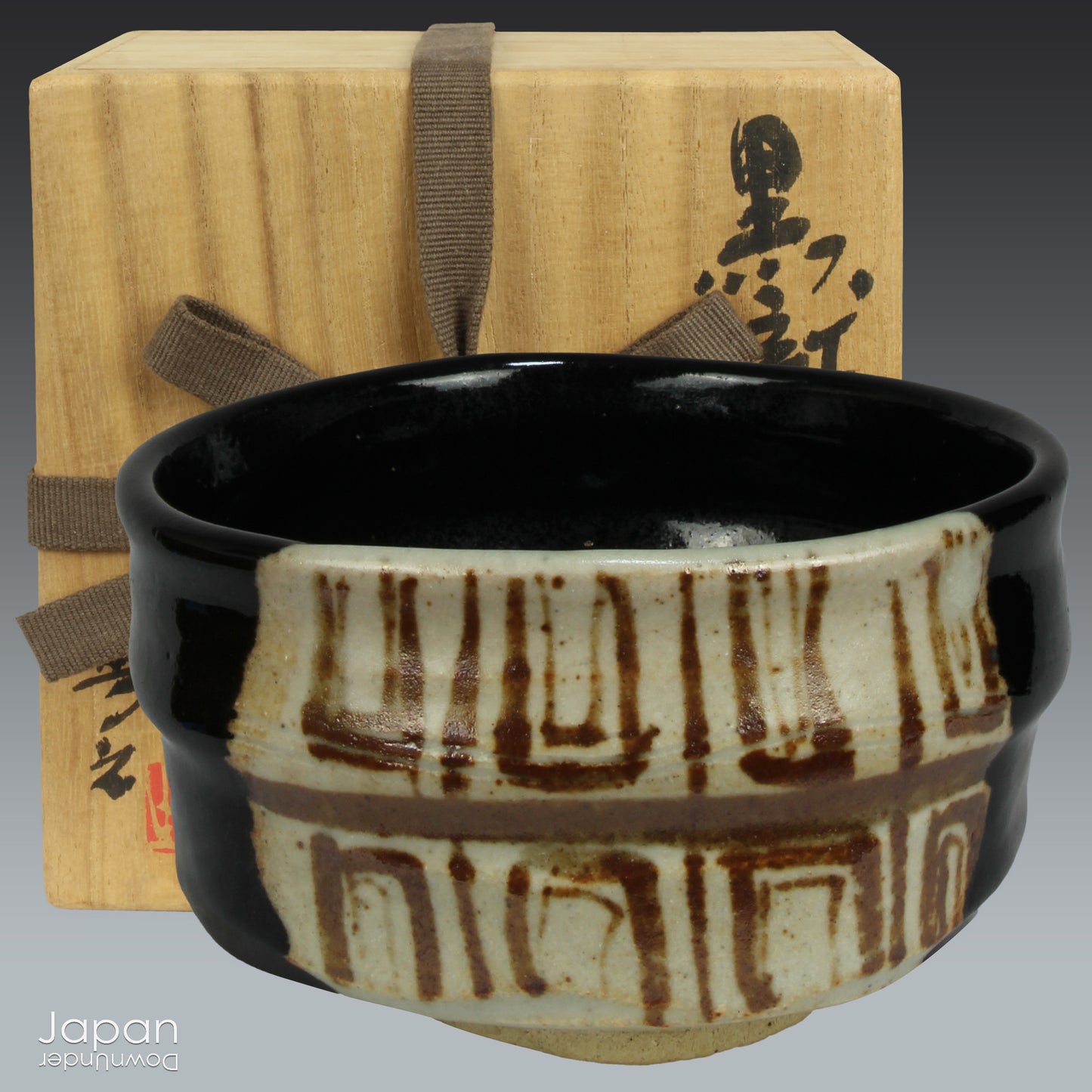 Experience the perfect blend of tradition and modernity with this stunning black Oribe matcha tea bowl. Crafted by the talented artist Yoshiyuki Sone, this unique piece boasts a contemporary design with a striking brown and beige geometric accent that adds a touch of sophistication to any tea ceremony.
The glossy black glaze of the bowl, paired with a minimalistic rectangular design, creates a striking contrast against the vibrant green matcha, making each sip feel even more special. True to the Oribe styl
