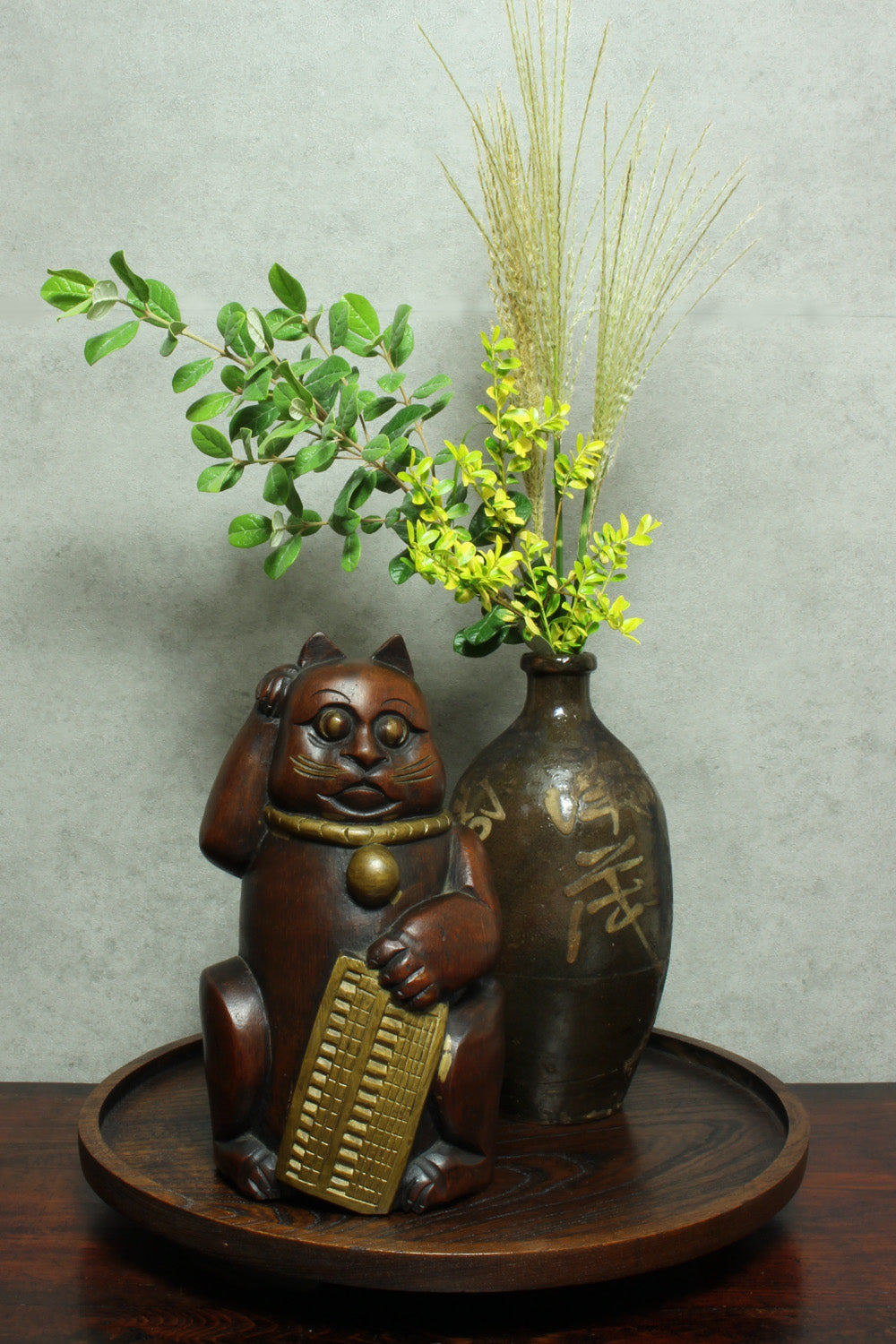 Add a touch of vintage charm to your home or office with this quaint Japanese maneki neko lucky cat. Crafted from bamboo, this larger sized cat,holding an abacus, is believed to beckon in wealth and good luck. Perfect for infusing positive energy and a touch of nostalgia into any space.
