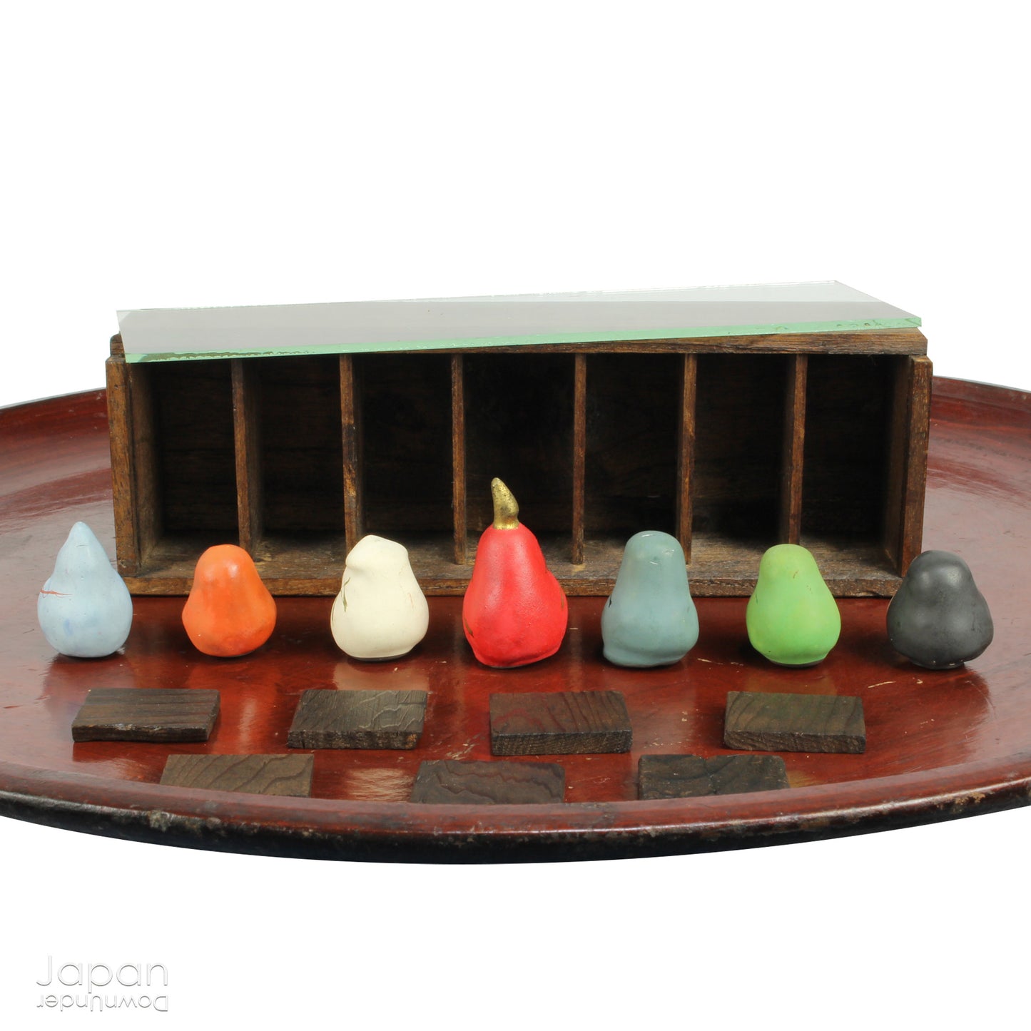 Invite good fortune and timeless tradition into your home with this quaint set of miniature antique Daruma charms. Housed in a charming wooden and glass display box, this unique collection adds an elegant and meaningful touch to your decor, perfect for any space seeking a blend of tradition, luck, and positive energy.
Crafted in the 1920s, this set features hand-painted clay Daruma figures representing the Seven Lucky Gods of Japan, each with its own powerful symbolism.