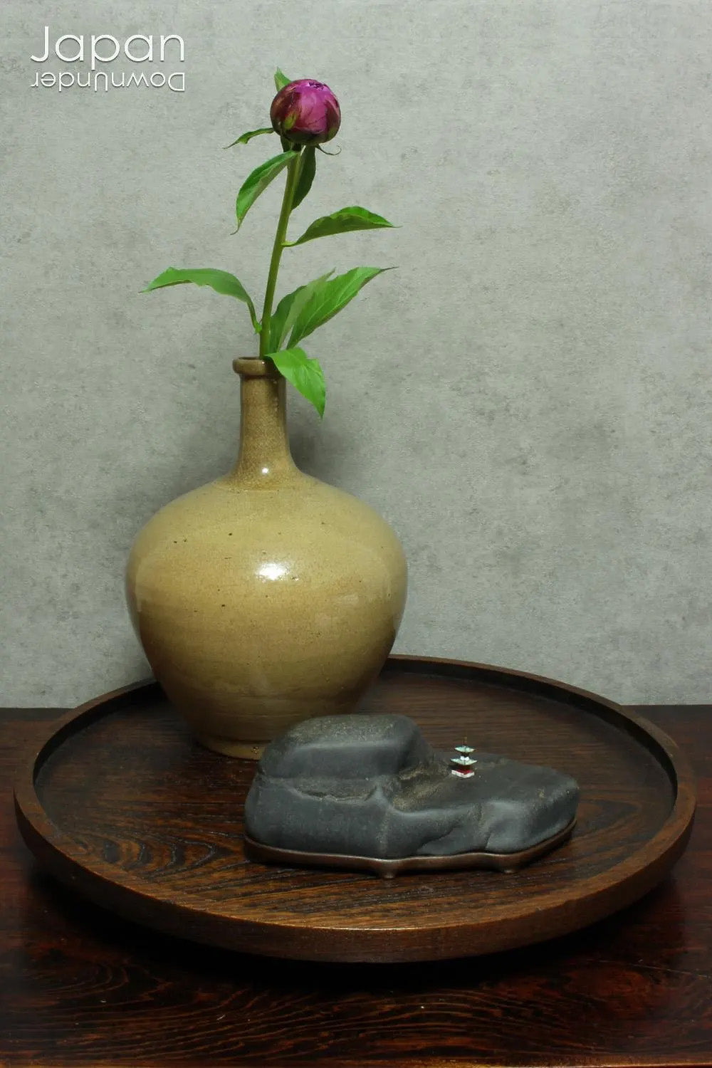 Introduce a quiet elegance and poetic depth to your space with this vintage Japanese suiseki - a contemplative stone shaped by nature and imbued with a serene, spiritual aura. Resting on a finely hand-carved daiza (wooden base) and accompanied by a small metal pagoda, this piece emanates stillness, balance, and an understated visual allure.