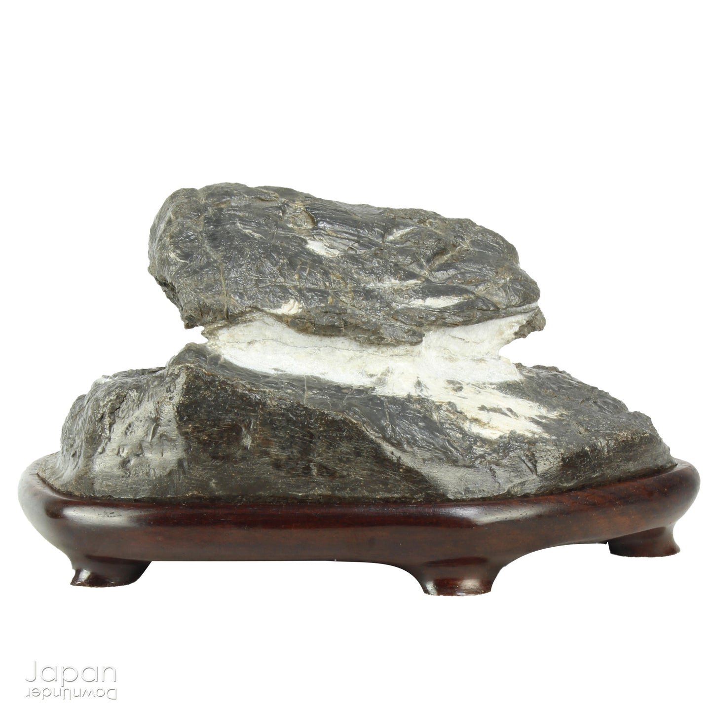 Immerse yourself in the meditative beauty of this captivating miniature suiseki - a traditional Japanese art form where nature is the true sculptor. Gracefully resting on a finely hand-carved ebony daiza (base), this stone embodies stillness and quiet strength, making it an ideal centerpiece for contemplative spaces, creative corners, or serene interiors.