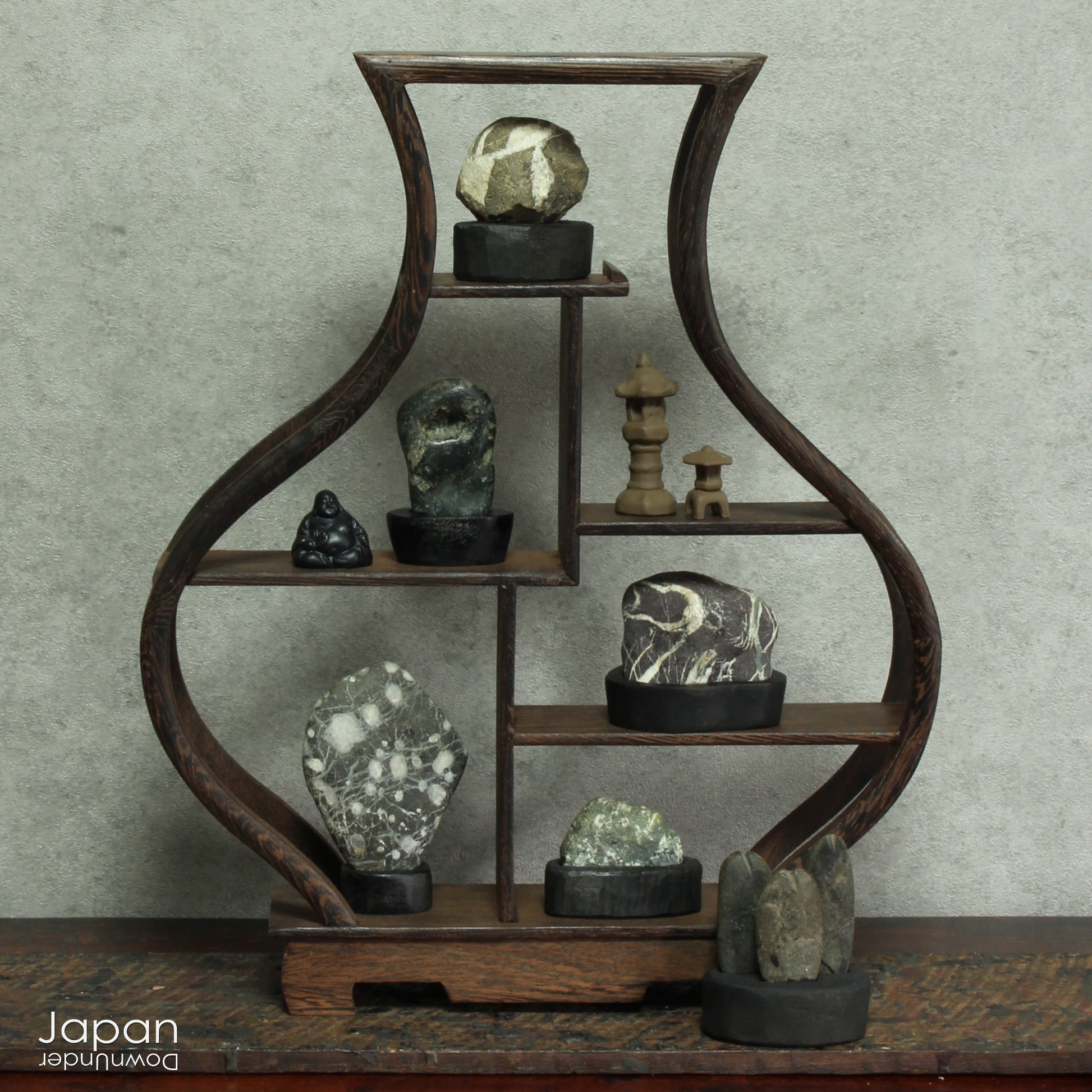 Elevate your home decor with this striking, modern collection of vintage Japanese miniature suiseki stones, beautifully arranged on a handcrafted, vase-shaped segmented shelf. These naturally sculpted stones evoke the essence of serene landscapes and bring a sense of harmony, sophistication, and contemplative stillness to any space.