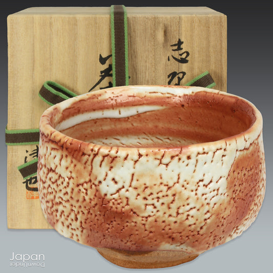 Elevate your tea ceremony with this stunning vintage matcha tea bowl, a piece that blends timeless beauty and exceptional craftsmanship. This one-of-a-kind bowl, with its delicate fusion of pale orange and white markings, is the perfect addition to your collection, allowing you to sip your matcha in style.
A Shino ware ceramic from Gifu Prefecture, this bowl features a soft, pale orange hue, enveloped in a thick, milky white glaze that creates a unique, curdled texture with charming tiny holes. The random