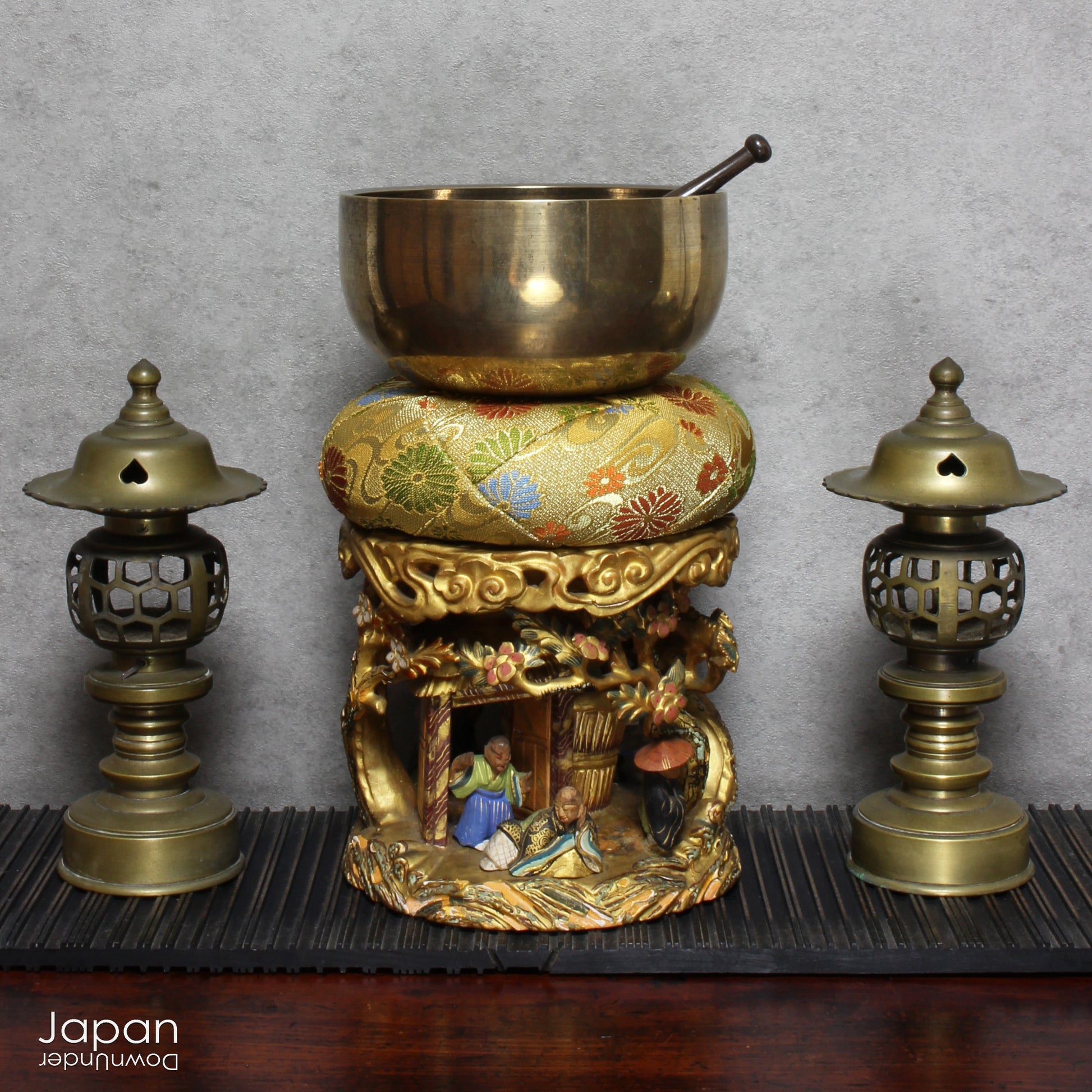 An 1800’s Buddhist altar singing bowl, harmoniously displayed on a traditional intricately carved custom order stand. Complete with a luxurious brocade cushion, this set exudes timeless elegance and spiritual significance.