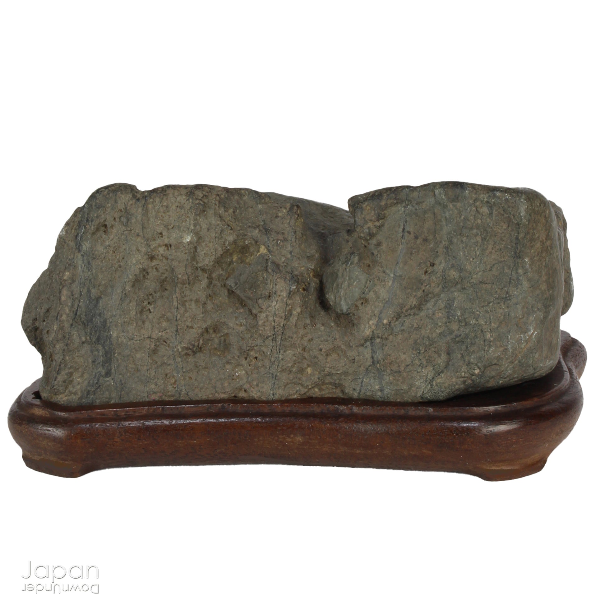 This vintage Japanese suiseki offers a quiet meditation on nature’s artistry ;a naturally weathered stone that embodies stillness, grace, and introspection. Resting atop an intricately hand-carved daiza, it invites the viewer into a space of reflection and reverence, where simplicity holds profound depth.
