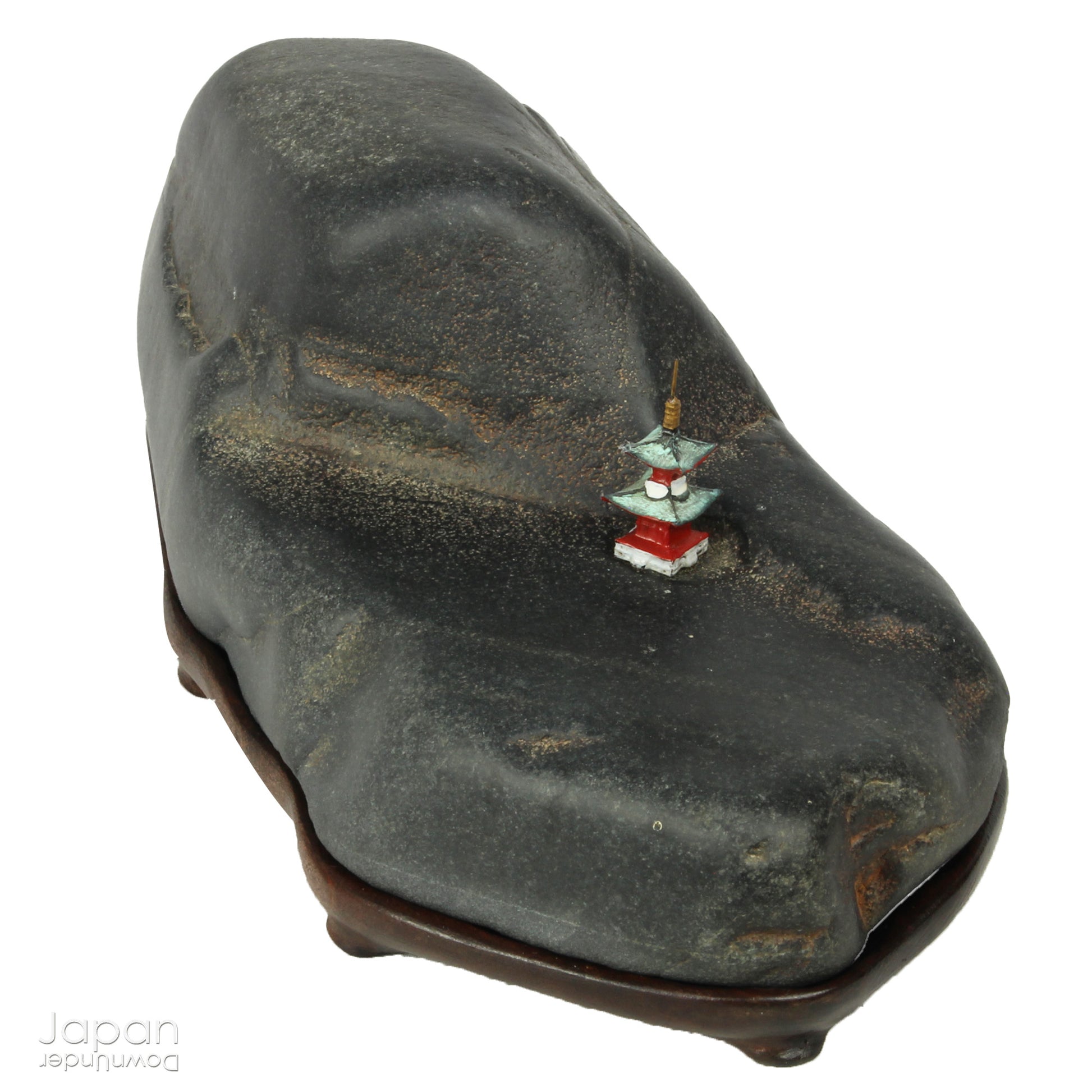 Introduce a quiet elegance and poetic depth to your space with this vintage Japanese suiseki - a contemplative stone shaped by nature and imbued with a serene, spiritual aura. Resting on a finely hand-carved daiza (wooden base) and accompanied by a small metal pagoda, this piece emanates stillness, balance, and an understated visual allure.