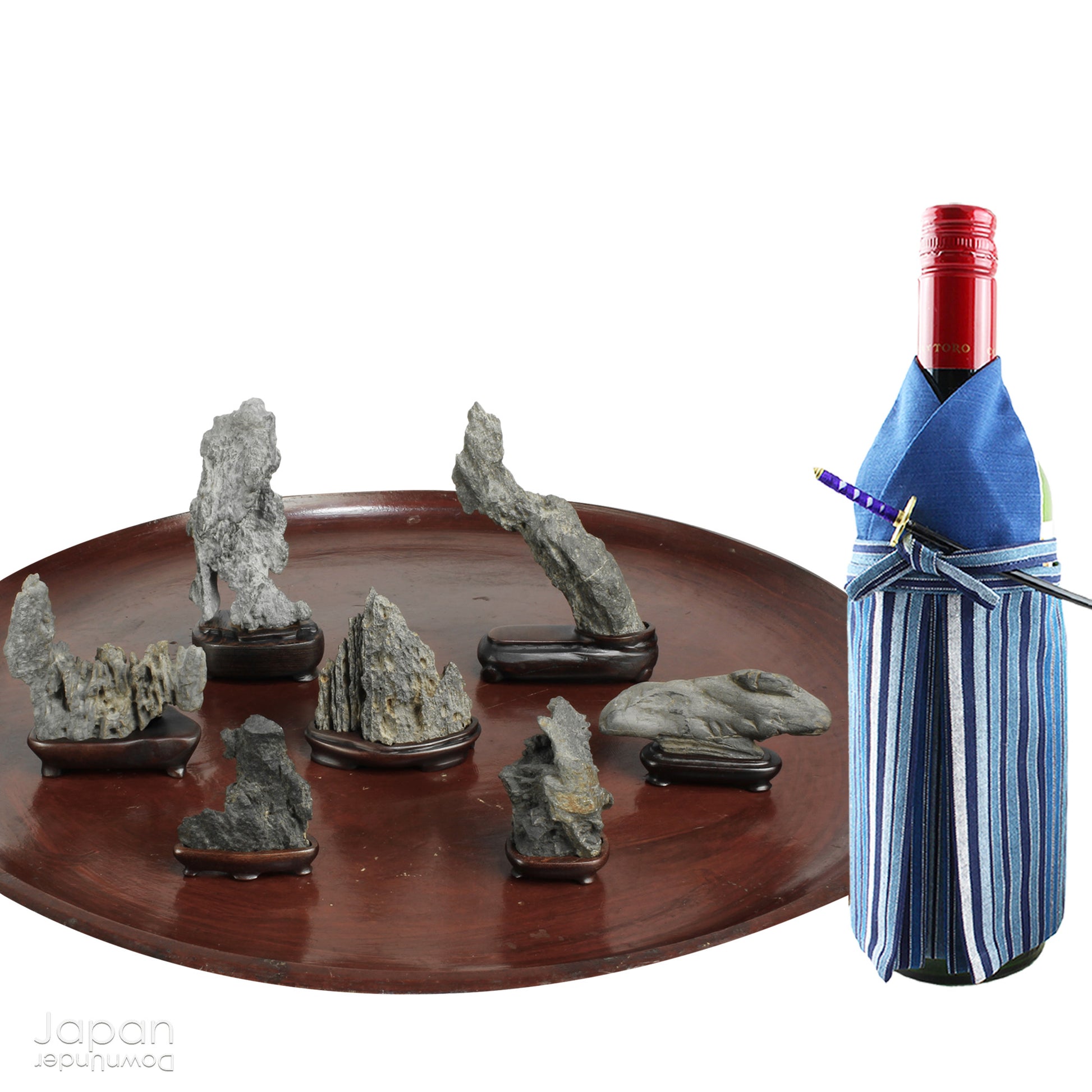 Invite serenity and understated beauty into your space with this remarkable collection of seven vintage miniature Japanese suiseki - natural “water stones” cherished for their quiet symbolism and evocative forms. Each small stone rests atop a finely hand-carved ebony daiza (stand), thoughtfully crafted to support and elevate its unique presence.