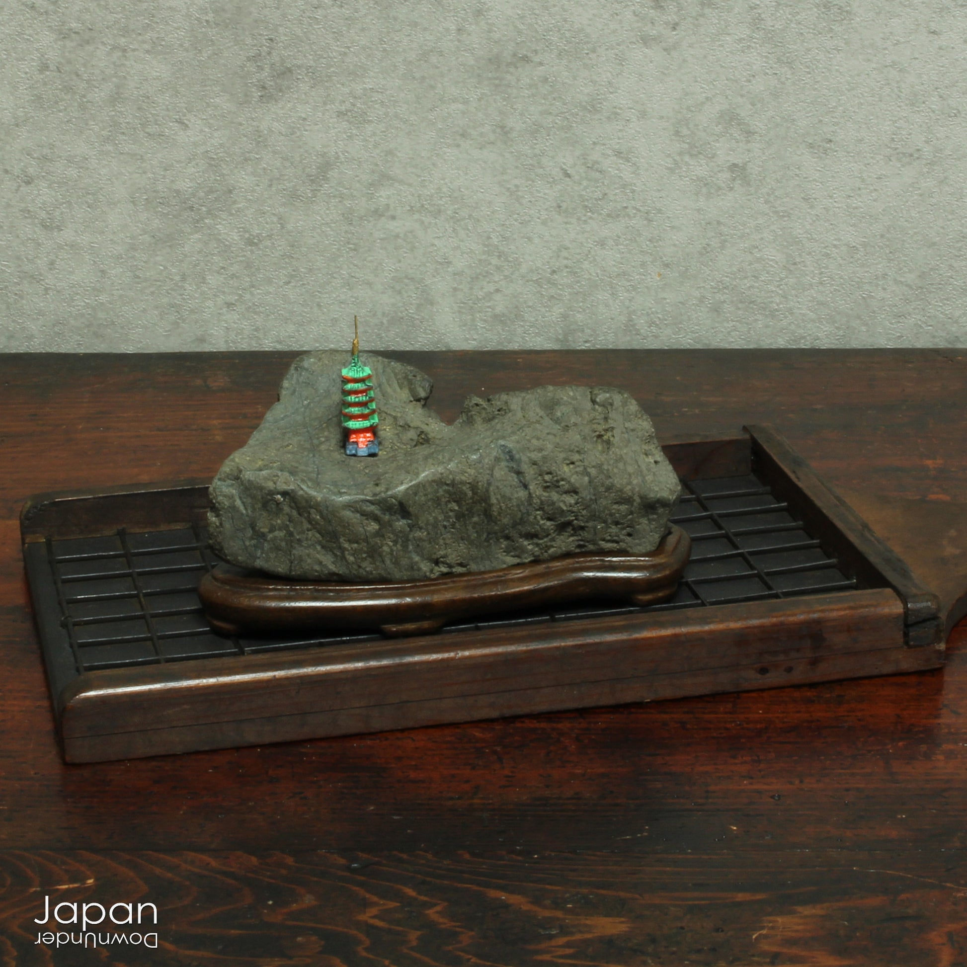This vintage Japanese suiseki offers a quiet meditation on nature’s artistry ;a naturally weathered stone that embodies stillness, grace, and introspection. Resting atop an intricately hand-carved daiza, it invites the viewer into a space of reflection and reverence, where simplicity holds profound depth.