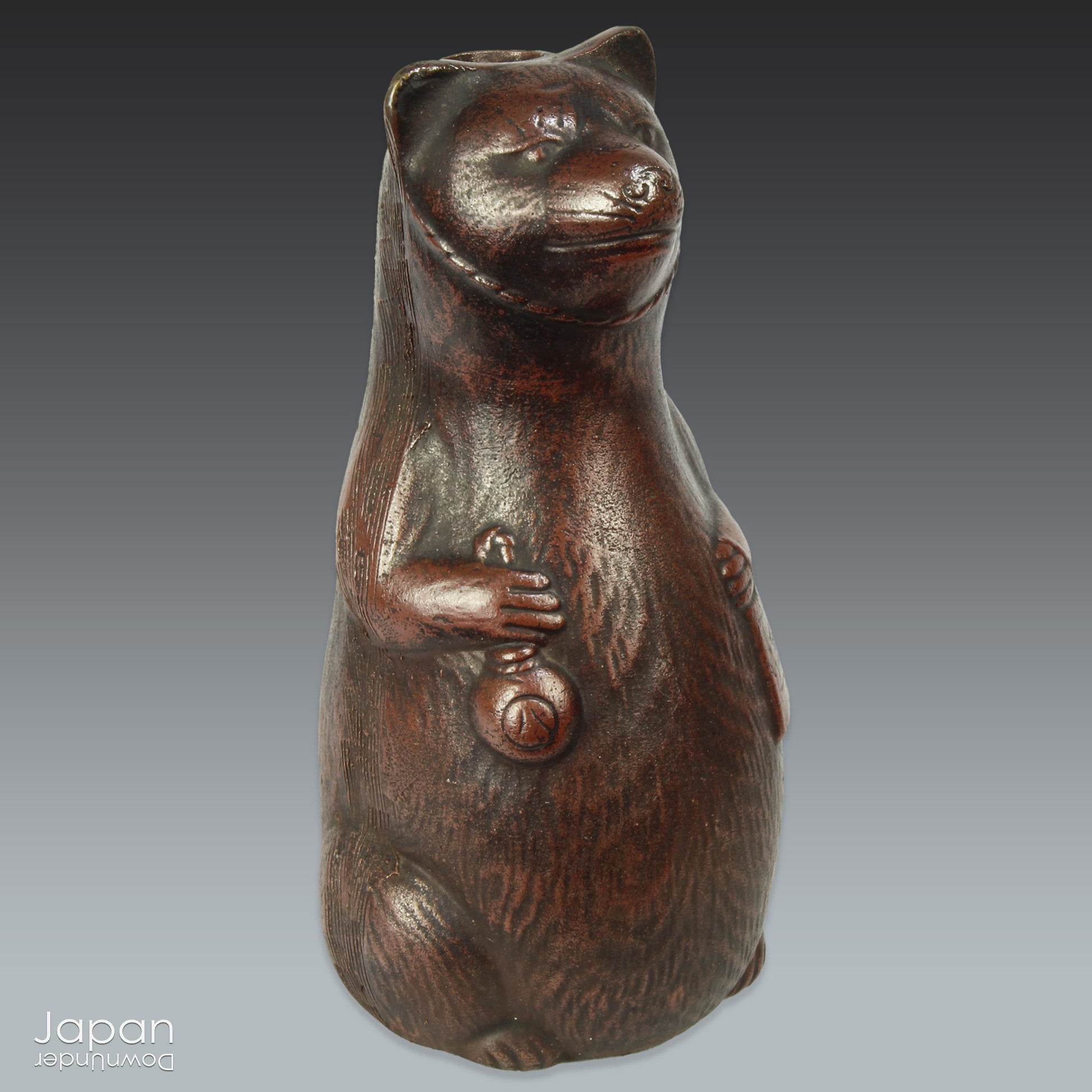 Infuse your space with the timeless elegance of Japanese craftsmanship and folklore through this antique Bizen raccoon dog tokkuri. Not only does it serve its traditional function as a sake pourer, but it also doubles as a captivating piece of art or a charming bud vase, making it a truly versatile addition to your collection.