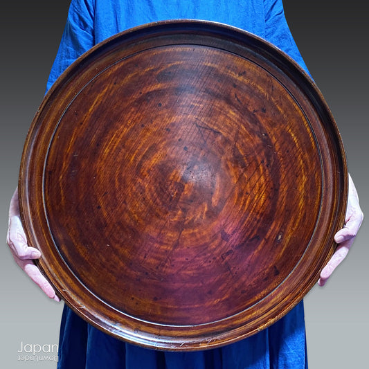 Add timeless charm and rustic elegance to your home with this exceptionally large antique round tea tray, hand-carved from a single cross-section of zelkova (keyaki) wood. A beautiful marriage of form and function, this piece serves equally well as a statement display stand, a unique tabletop, or a traditional tea-serving tray.
