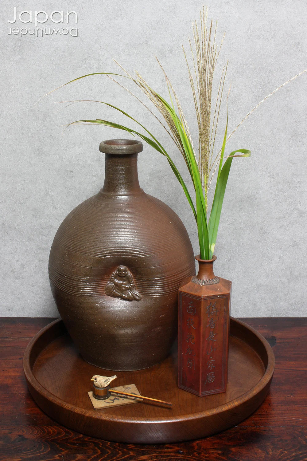 Add depth and story to your interior with this striking Taisho-era Bizen ware sake tokkuri, adorned with Hotei - the cheerful god of happiness, children, and good fortune, and one of Japan’s beloved Seven Lucky Gods. More than just a vessel, this antique bottle is a captivating example of Japanese folk craftsmanship, equally compelling as a sculptural display piece or a uniquely soulful vase.