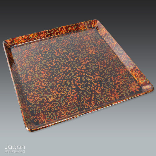 Add a bold splash of artistry to your table with this striking square serving tray, crafted in the traditional Ka-nuri style of Tsugaru lacquerware from Aomori Prefecture, Japan. With its rich blend of bronze, orange-red, black, and gold hues, and a mesmerizing speckled finish, this tray isn't just functional - it's a statement piece.