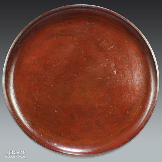 A stunning 1800’s Japanese folk art round serving tray. This versatile piece doubles as a unique display stand adding a touch of rustic charm to any decor. The beautiful dark wine red and black color palette showcases the wonderful patina of use, making it a truly one-of-a-kind art object.
