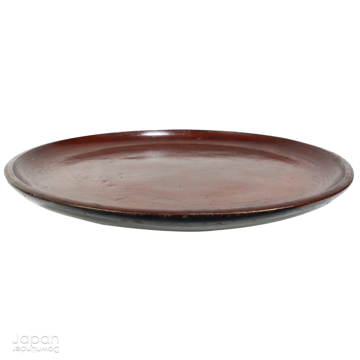 A stunning 1800’s Japanese folk art round serving tray. This versatile piece doubles as a unique display stand adding a touch of rustic charm to any decor. The beautiful dark wine red and black color palette showcases the wonderful patina of use, making it a truly one-of-a-kind art object.