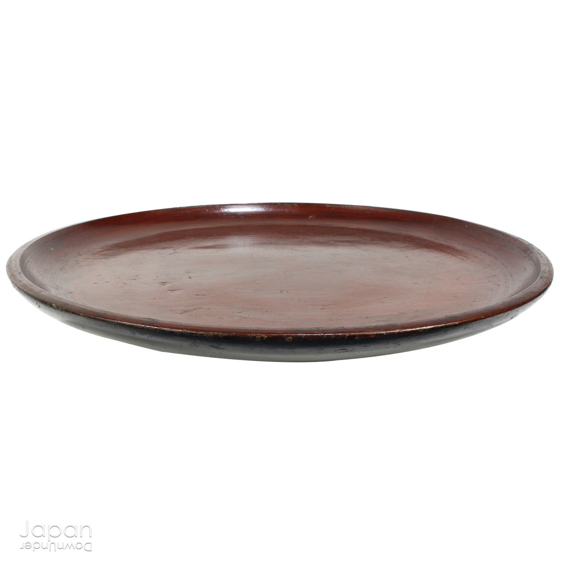 A stunning 1800’s Japanese folk art round serving tray. This versatile piece doubles as a unique display stand adding a touch of rustic charm to any decor. The beautiful dark wine red and black color palette showcases the wonderful patina of use, making it a truly one-of-a-kind art object.
