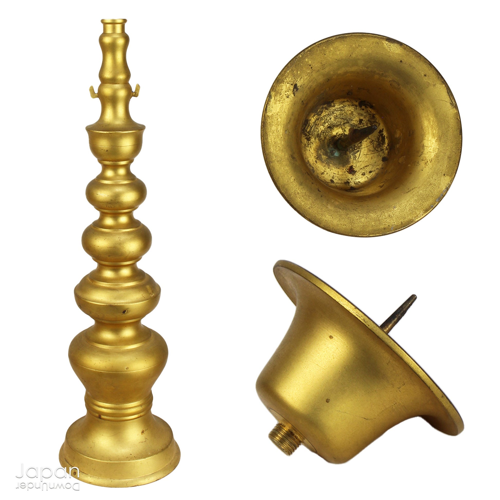 An antique Buddhist temple candle holder.    The gilded brass candle holder is a cylindrical shape, formed of spheres,  gradually decreasing in size as they move upwards. Just below the candle cup hang a pair of Japanese komainu, or lion dogs.