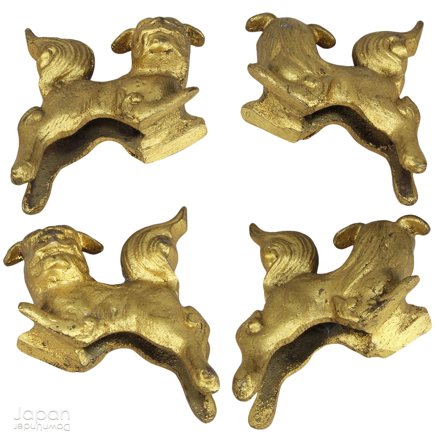 An antique Buddhist temple candle holder.    The gilded brass candle holder is a cylindrical shape, formed of spheres,  gradually decreasing in size as they move upwards. Just below the candle cup hang a pair of Japanese komainu, or lion dogs.