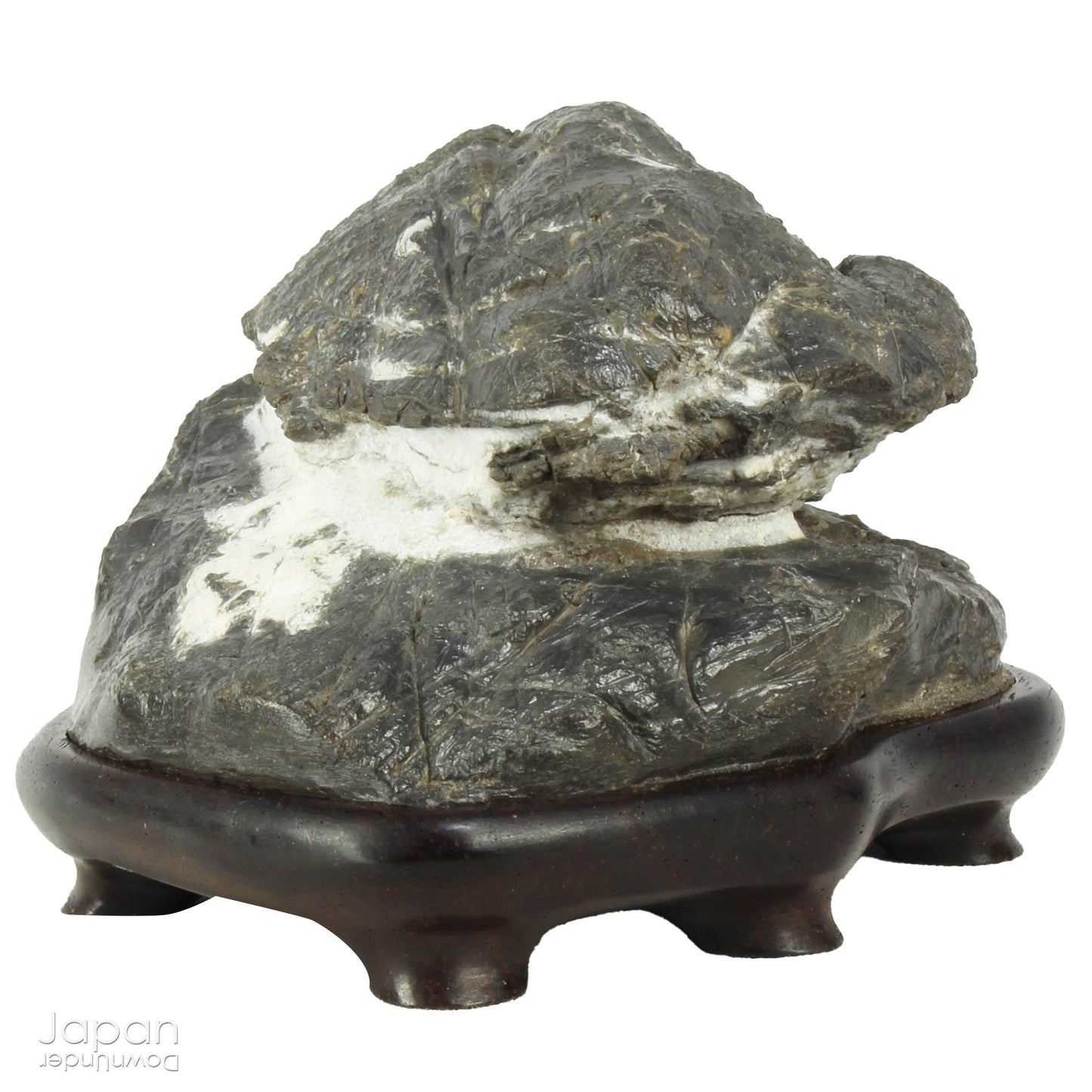 Immerse yourself in the meditative beauty of this captivating miniature suiseki - a traditional Japanese art form where nature is the true sculptor. Gracefully resting on a finely hand-carved ebony daiza (base), this stone embodies stillness and quiet strength, making it an ideal centerpiece for contemplative spaces, creative corners, or serene interiors.