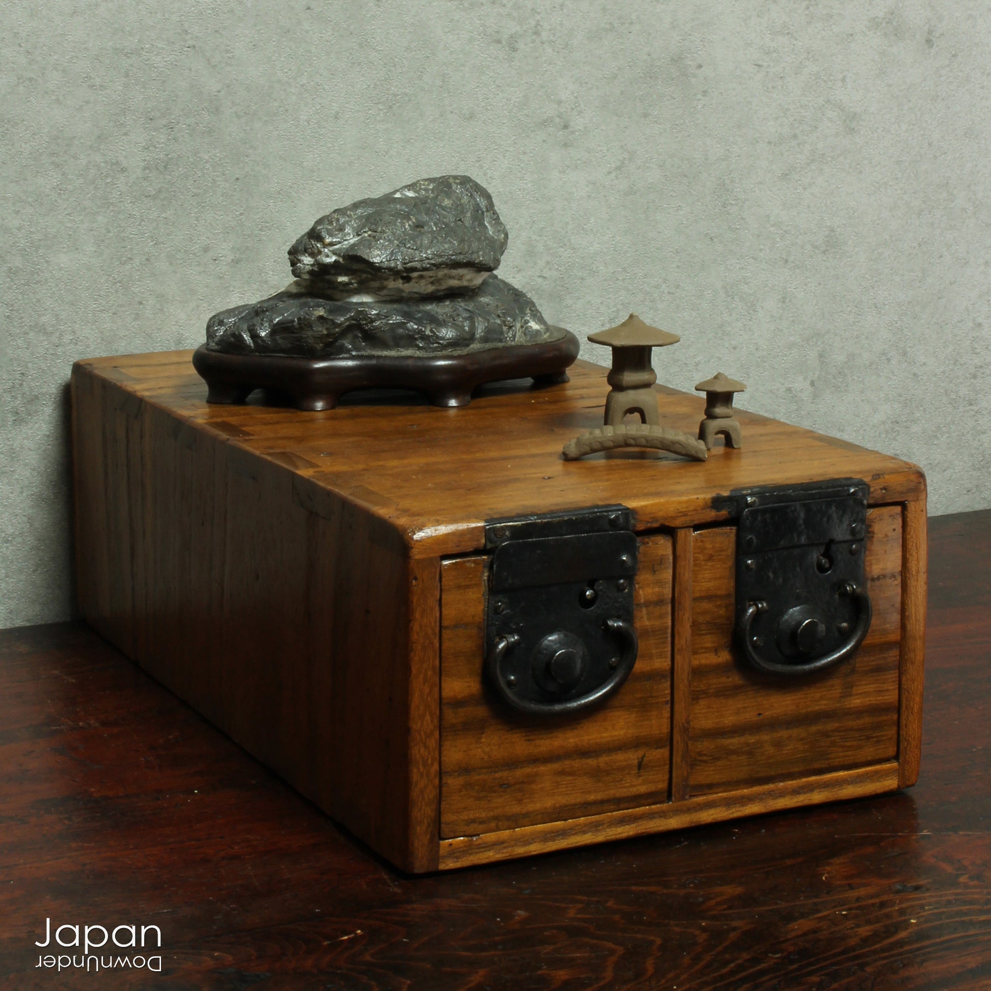 Immerse yourself in the meditative beauty of this captivating miniature suiseki - a traditional Japanese art form where nature is the true sculptor. Gracefully resting on a finely hand-carved ebony daiza (base), this stone embodies stillness and quiet strength, making it an ideal centerpiece for contemplative spaces, creative corners, or serene interiors.