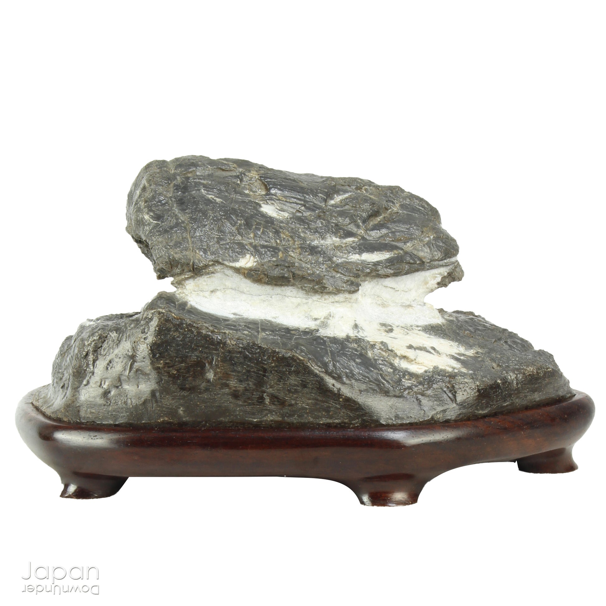 Immerse yourself in the meditative beauty of this captivating miniature suiseki - a traditional Japanese art form where nature is the true sculptor. Gracefully resting on a finely hand-carved ebony daiza (base), this stone embodies stillness and quiet strength, making it an ideal centerpiece for contemplative spaces, creative corners, or serene interiors.