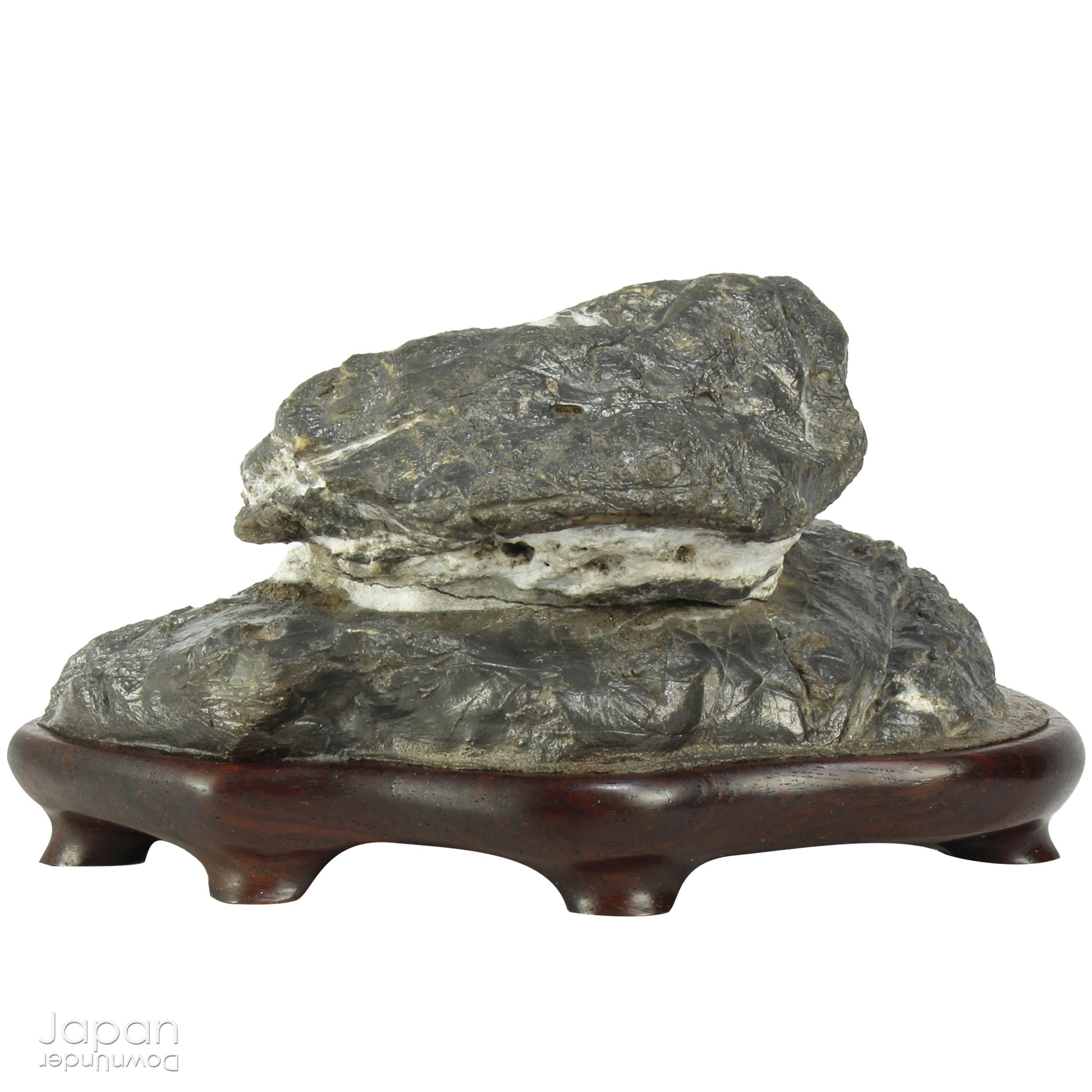 Immerse yourself in the meditative beauty of this captivating miniature suiseki - a traditional Japanese art form where nature is the true sculptor. Gracefully resting on a finely hand-carved ebony daiza (base), this stone embodies stillness and quiet strength, making it an ideal centerpiece for contemplative spaces, creative corners, or serene interiors.